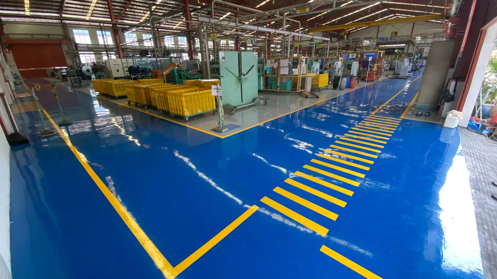 Lantai epoxy biru dengan jalur pejalan kaki di pabrik